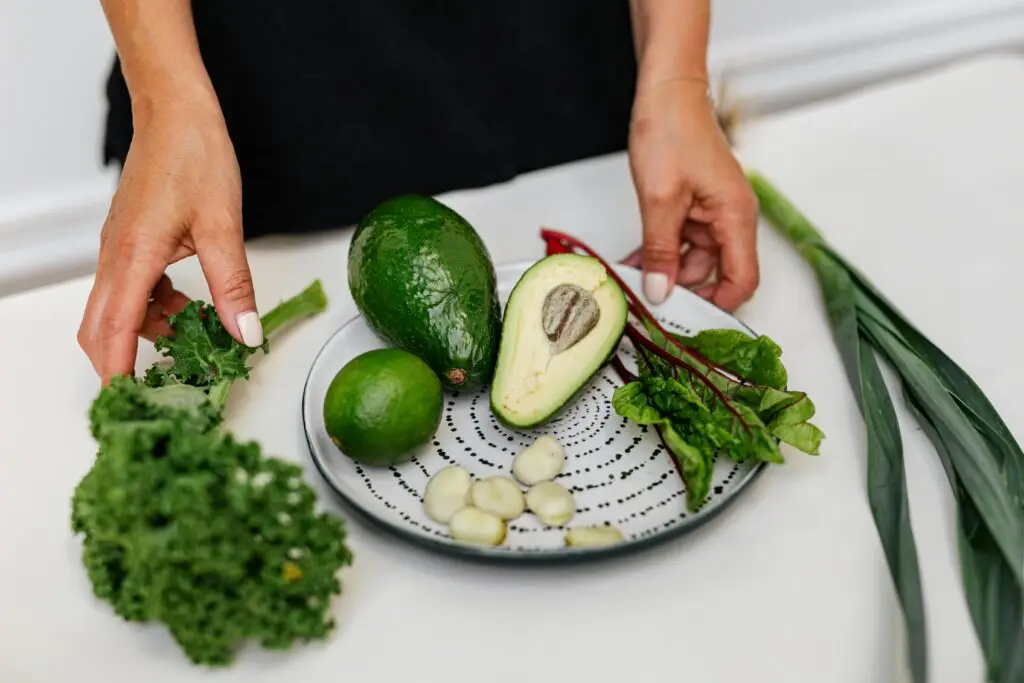 Top view of assorted fresh ingredients including avocado and kale on a plate. Perfect for healthy eating themes.